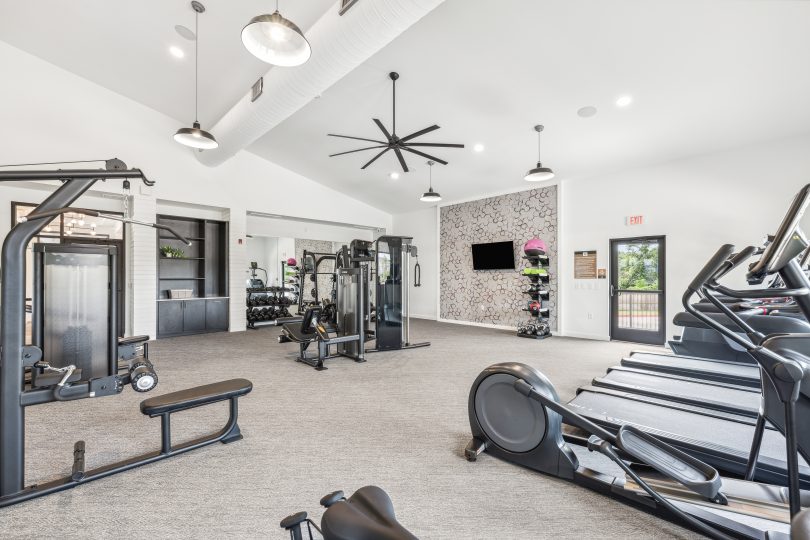 a gym room with tread machines and a ceiling fan at The Rushcreek