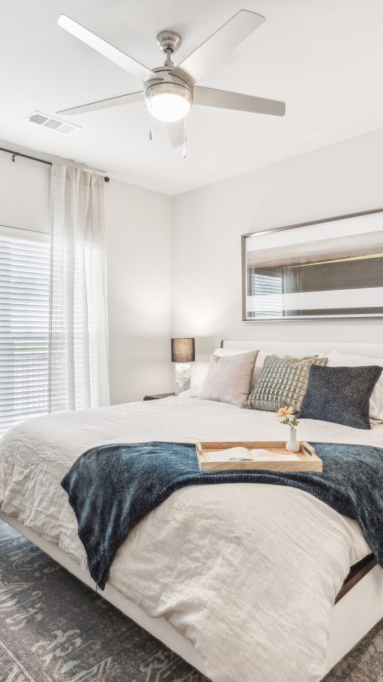 a bedroom with a ceiling fan and white bed at The Rushcreek